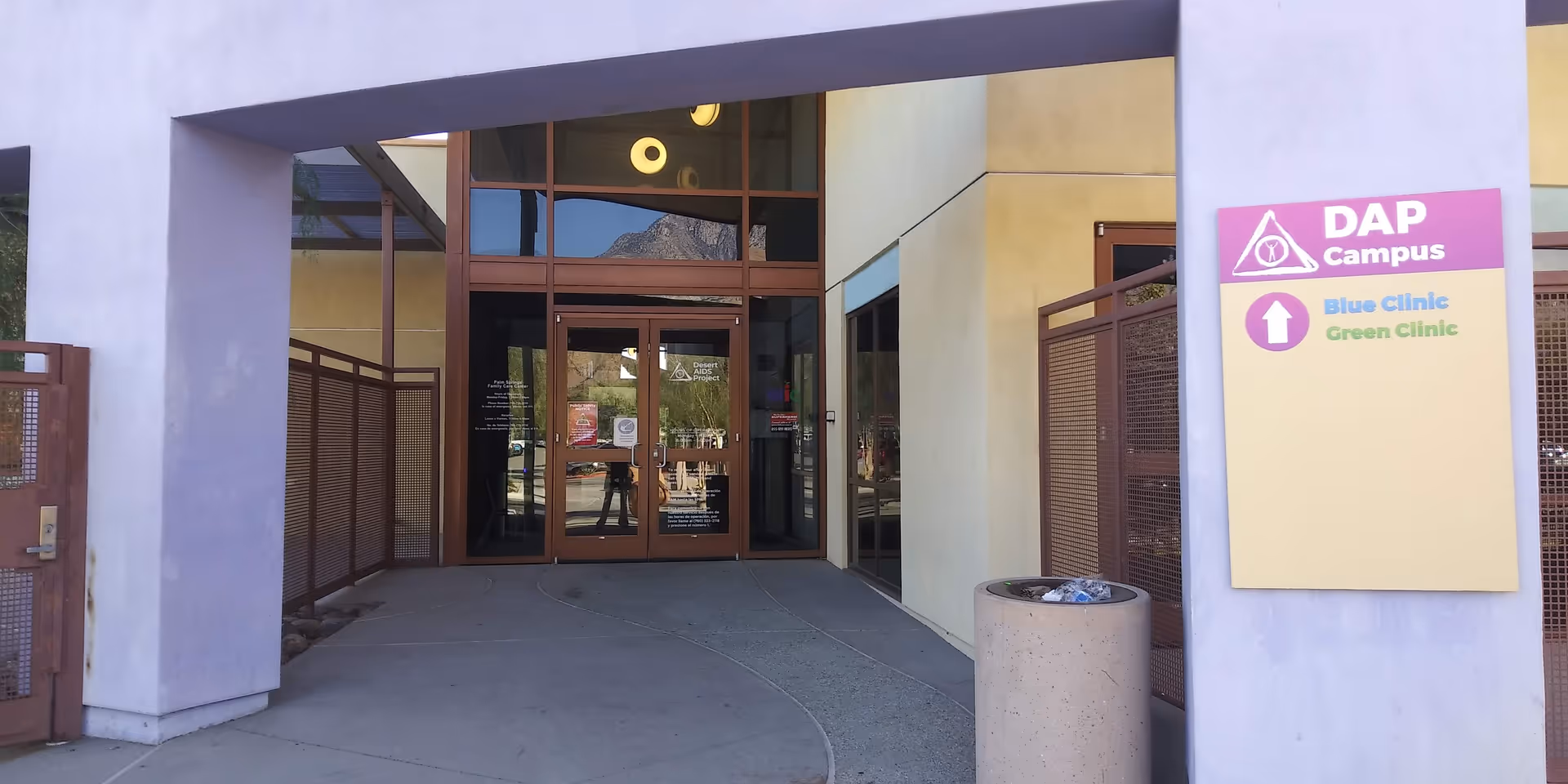 Modern facility entrance with glass doors, purple wall, and a DAP Health sign.
