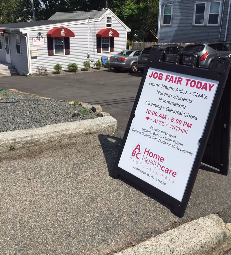 Exterior view of a small building with a Job Fair signboard outside.