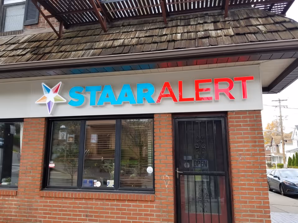 Exterior of a brick storefront with a bright STAAR ALERT sign and star logo.