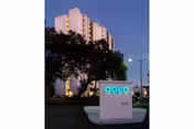 Exterior view of Aqua Apartments sign with a high-rise building in the background.