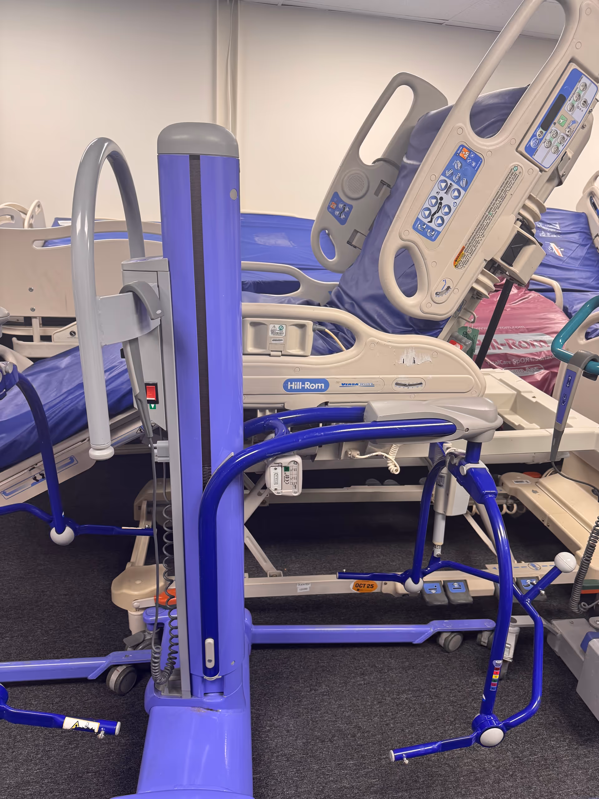 Hospital-style bed with medical controls and purple equipment in a care facility room