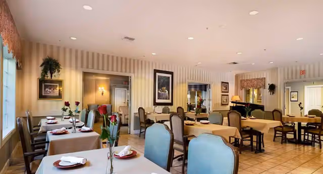 A well-lit dining room with multiple tables set for meals.