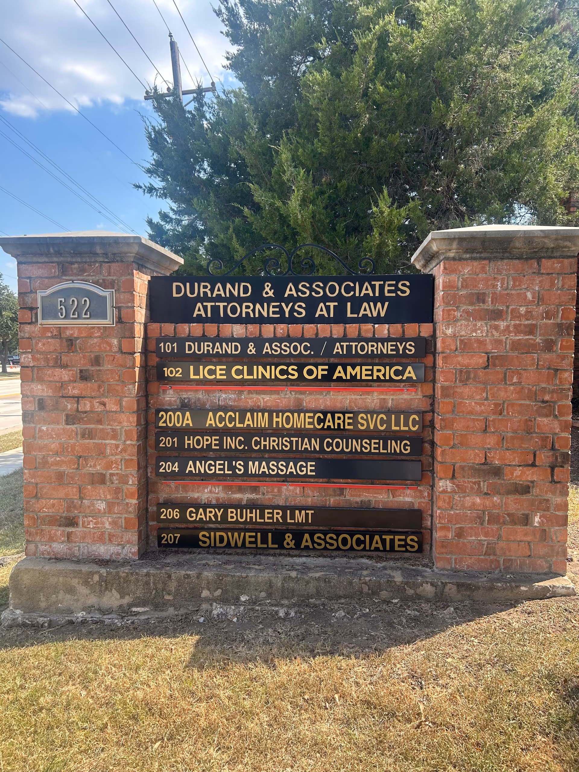 Directory sign listing Acclaim Homecare Svc LLC among other tenants on brick pillars