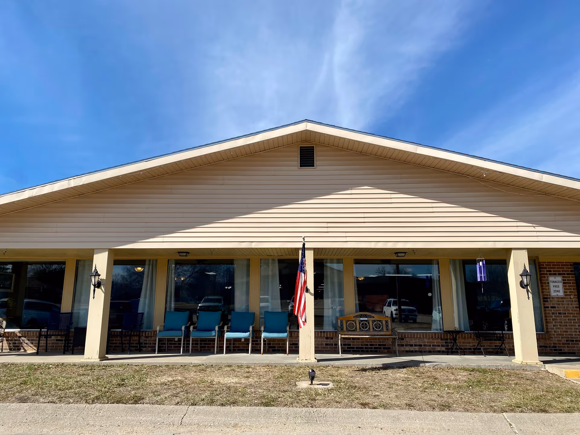 Front view of Belleville Health Care Center with a shaded porch and chairs.