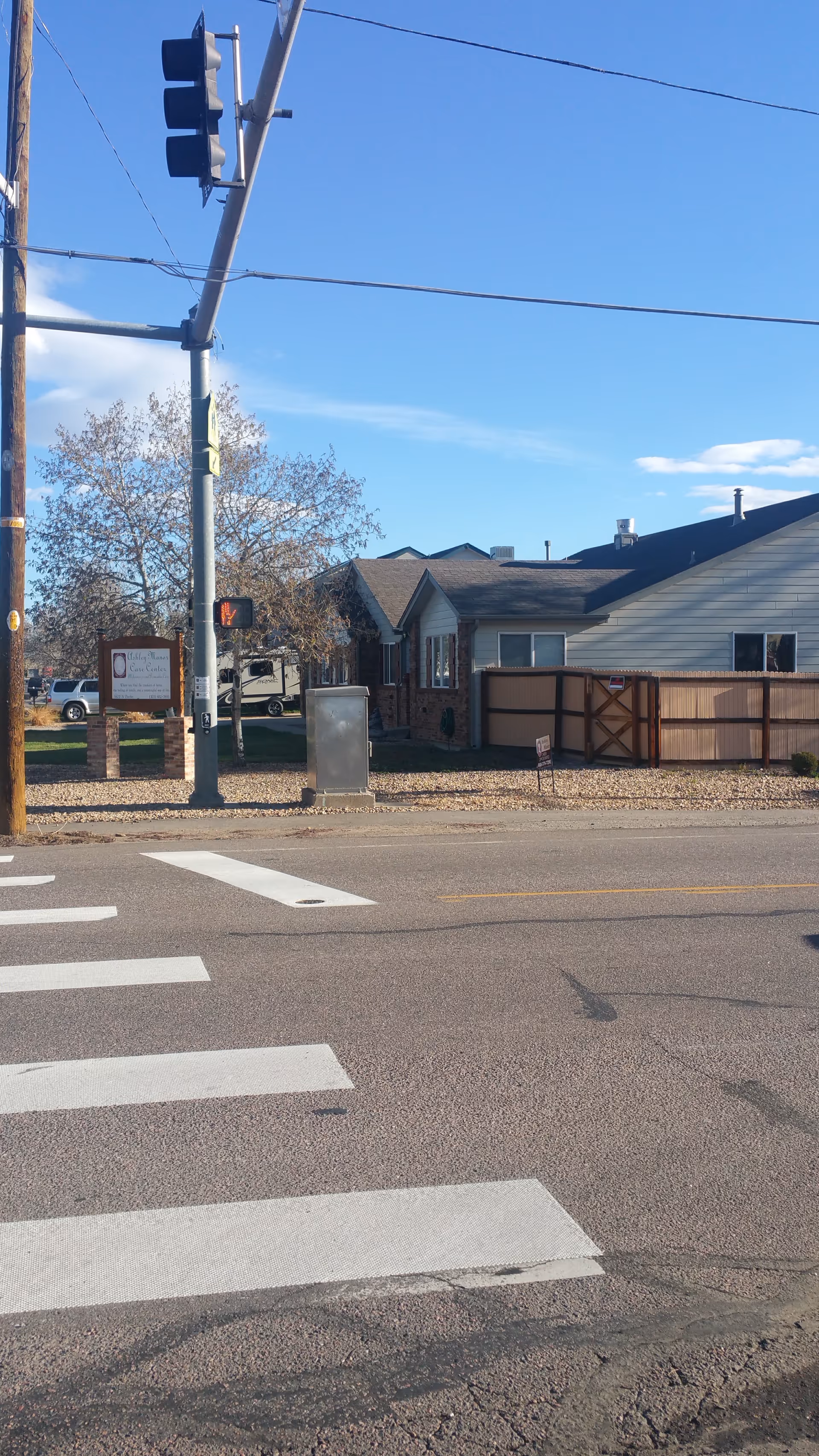 Exterior street view with crosswalks, utility pole, and a single building.