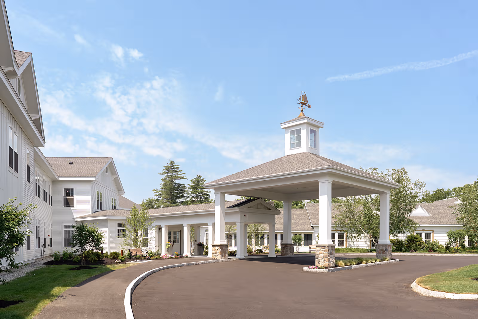 Exterior view of Benchmark at Rye facility with white buildings, porte-cochere, and landscaping