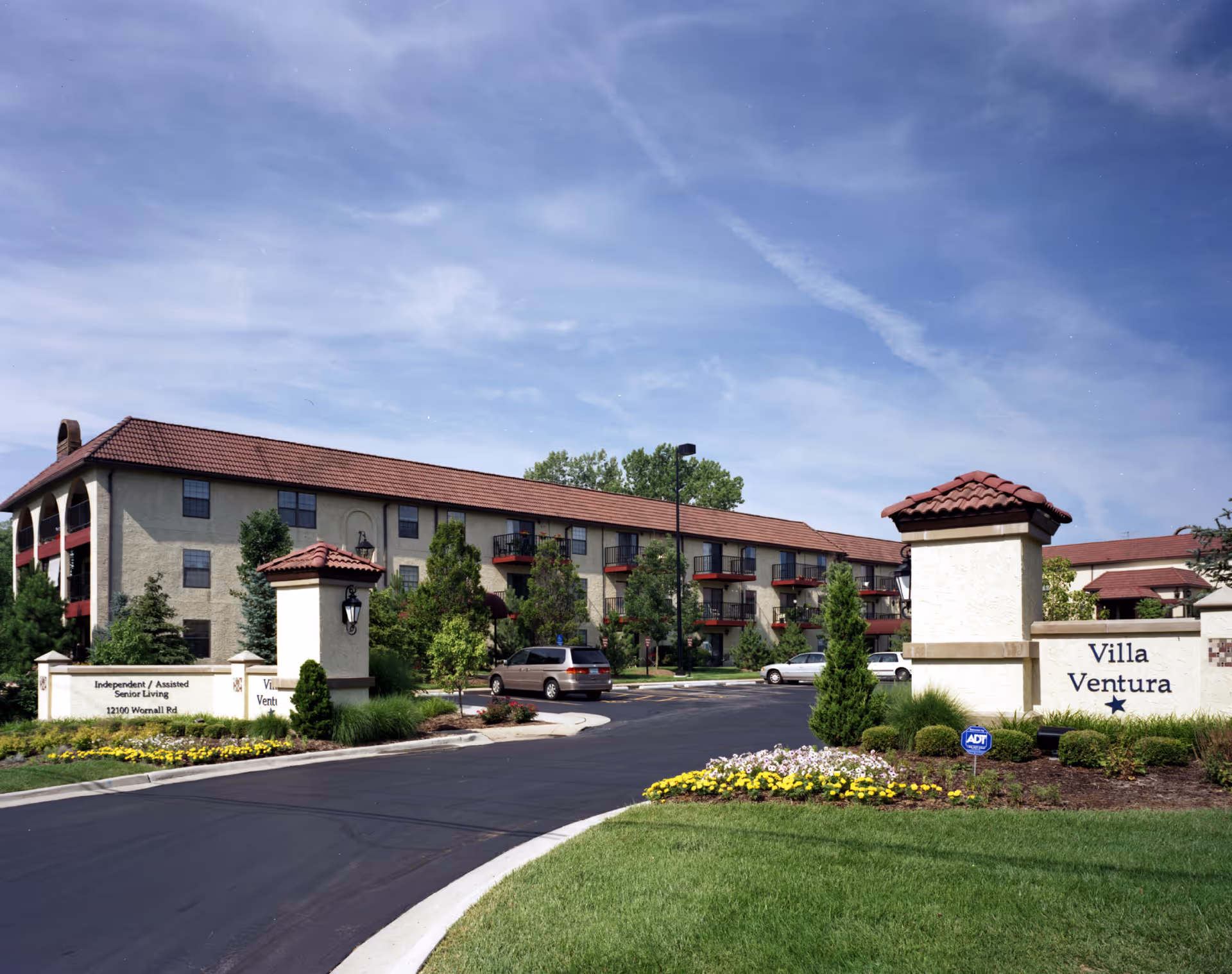 Wide exterior view of Senior Star at Villa Ventura with landscaped entrance and sign.