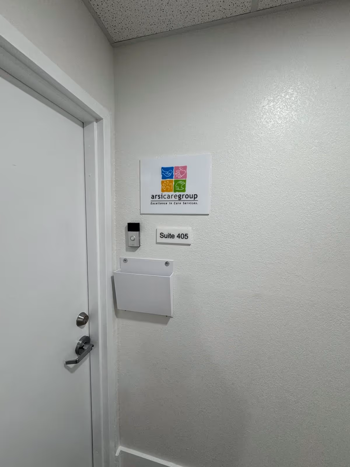 White hallway with door and wall plaque reading Arsi Care Group, Suite 405.