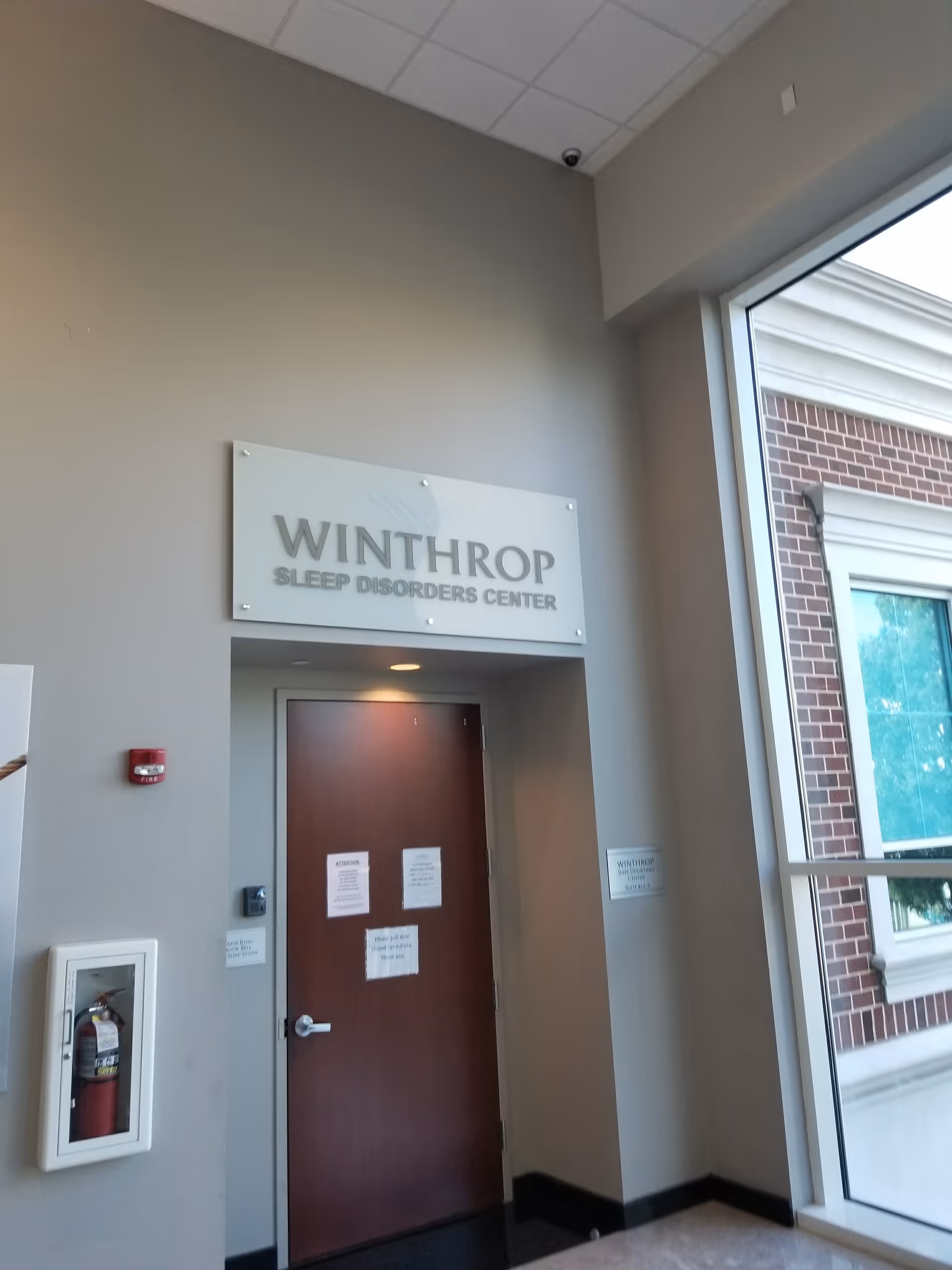 Interior lobby area with a sign reading WINTHROP SLEEP DISORDERS CENTER above a wooden door.