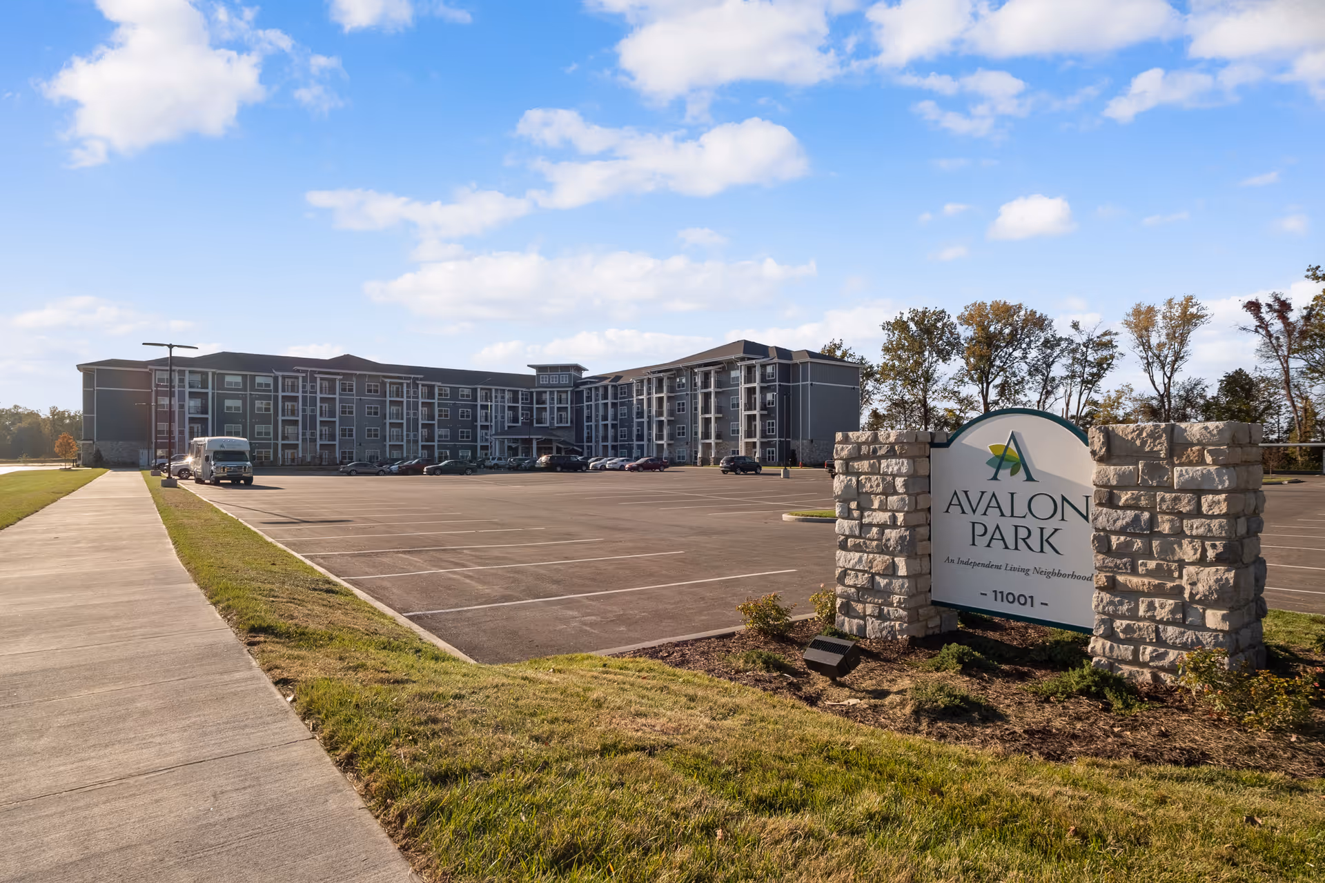 Exterior view of Avalon Park Independent Living building, parking lot, and entrance sign.