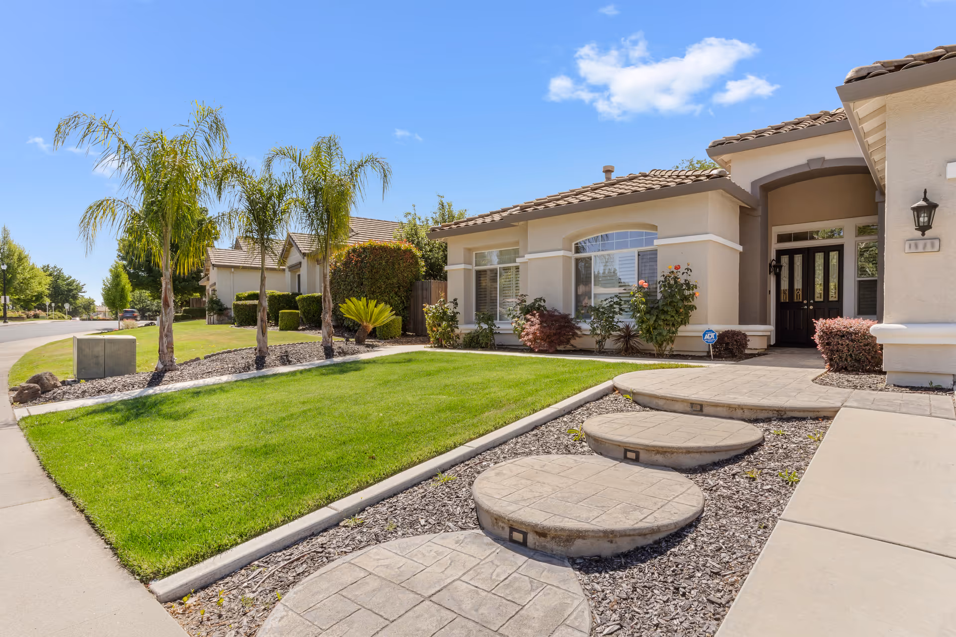 A single-story senior living facility with a manicured lawn and arched entrance.