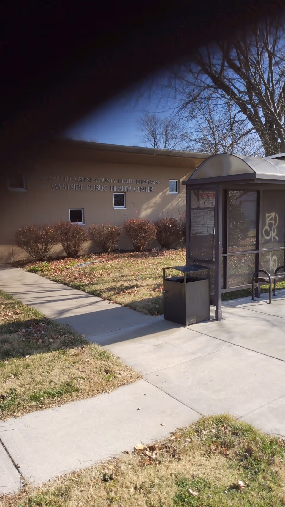 Exterior view of Westside Public Health Center with a bus shelter and walkway