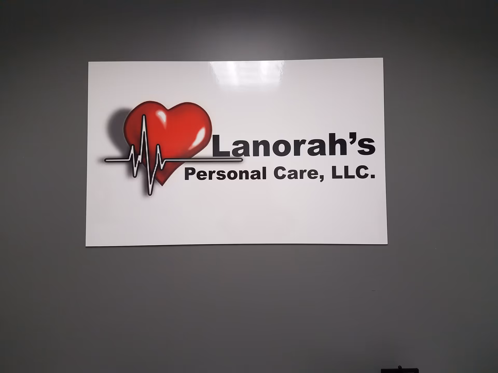 White rectangular sign with a red heart logo and 'Lanorah's Personal Care, LLC' text.