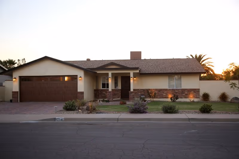 Single-story assisted living facility exterior with brick accents and a two-car garage.