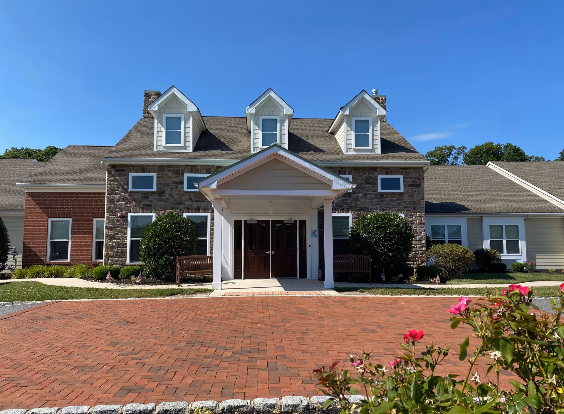 Front view of Mullica Gardens Assisted Living building with brick, stone facade and entrance.