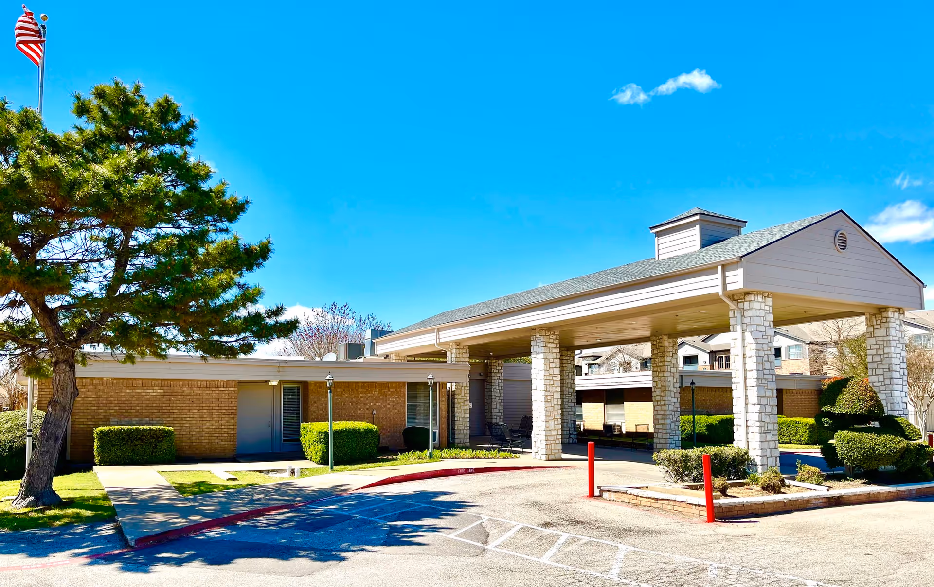 Exterior view of Senior Care Beltline facility with brick walls and porte-cochere under blue sky