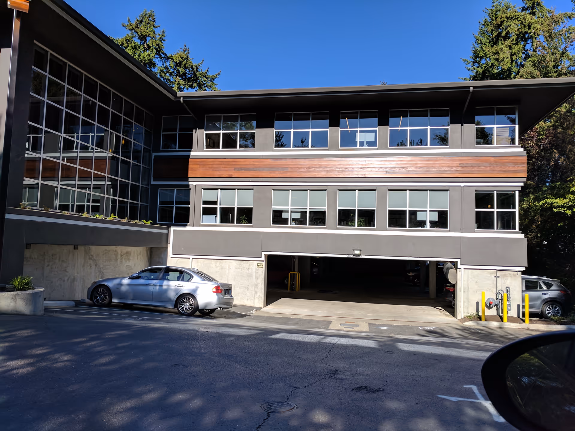 Exterior view of a modern Aegis Living facility with parked cars.