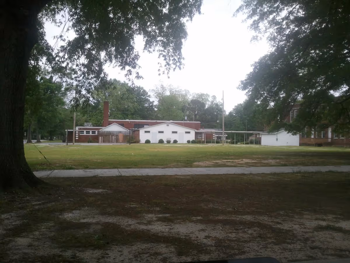 Wide exterior view of Senior Home Care Services with lawn and trees.