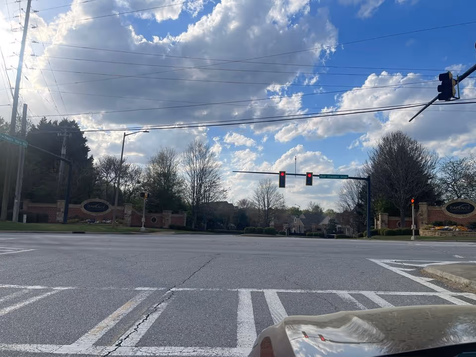 Street-level view across an intersection of the Cadence - Canton entrance and signage beneath a partly cloudy sky.