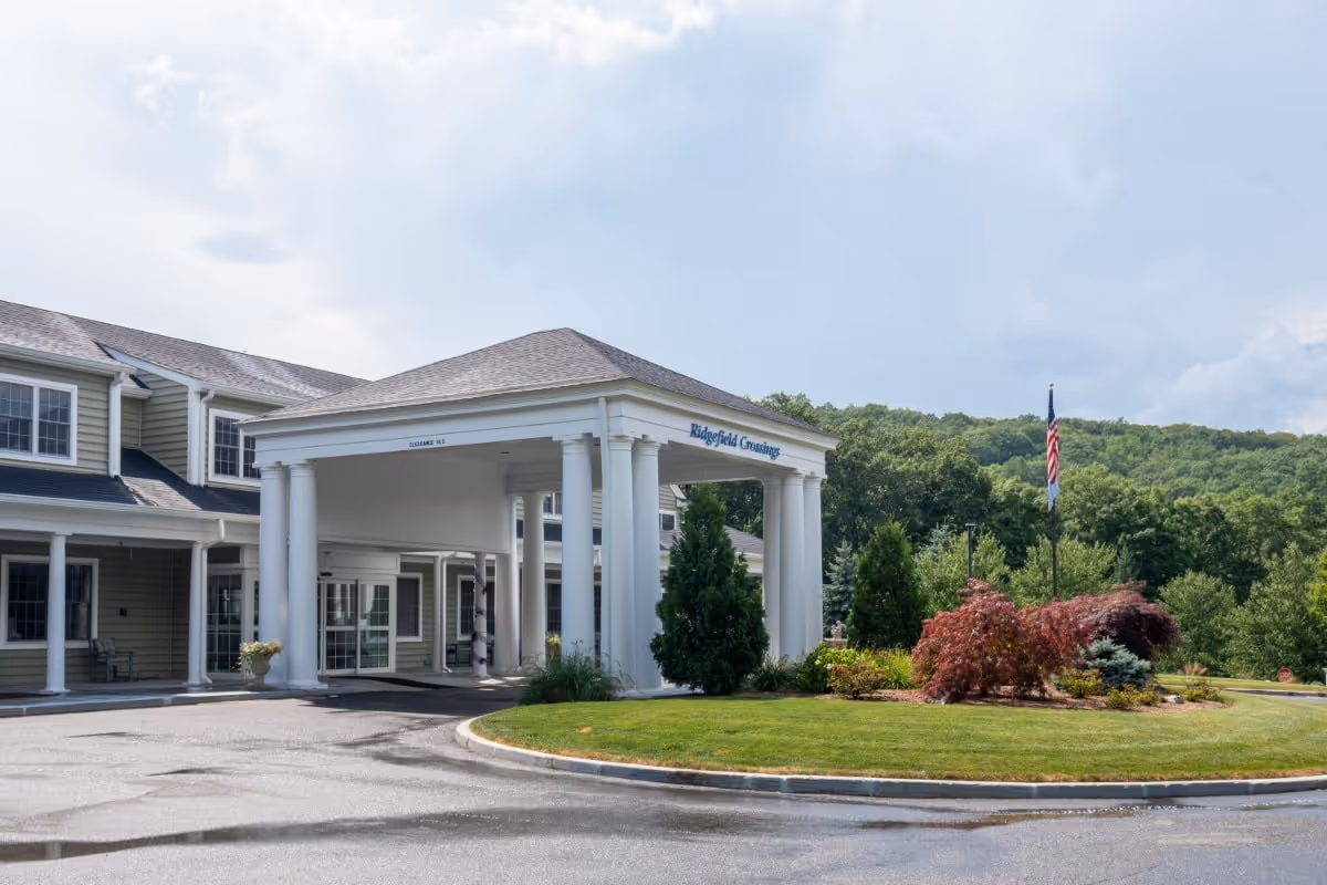 Exterior view of Benchmark at Ridgefield Crossings entrance with white columns and landscaping.