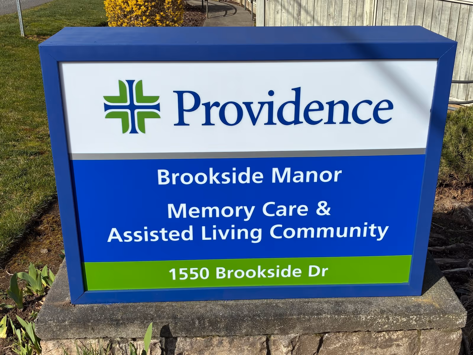 Blue Providence sign on a concrete base reads Brookside Manor Memory Care and Assisted Living Community.