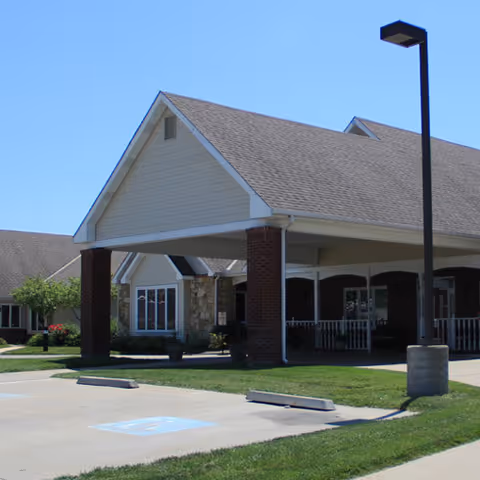 Front view of Vintage Park at Baldwin City building with covered entrance and parking.