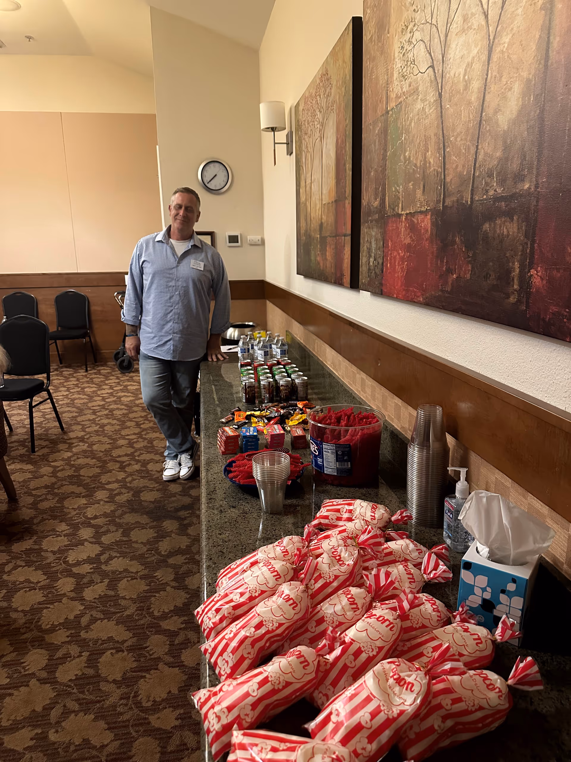 Staff member standing beside a snack table in a lounge at Home Matters Caregiving - Wilsonville.