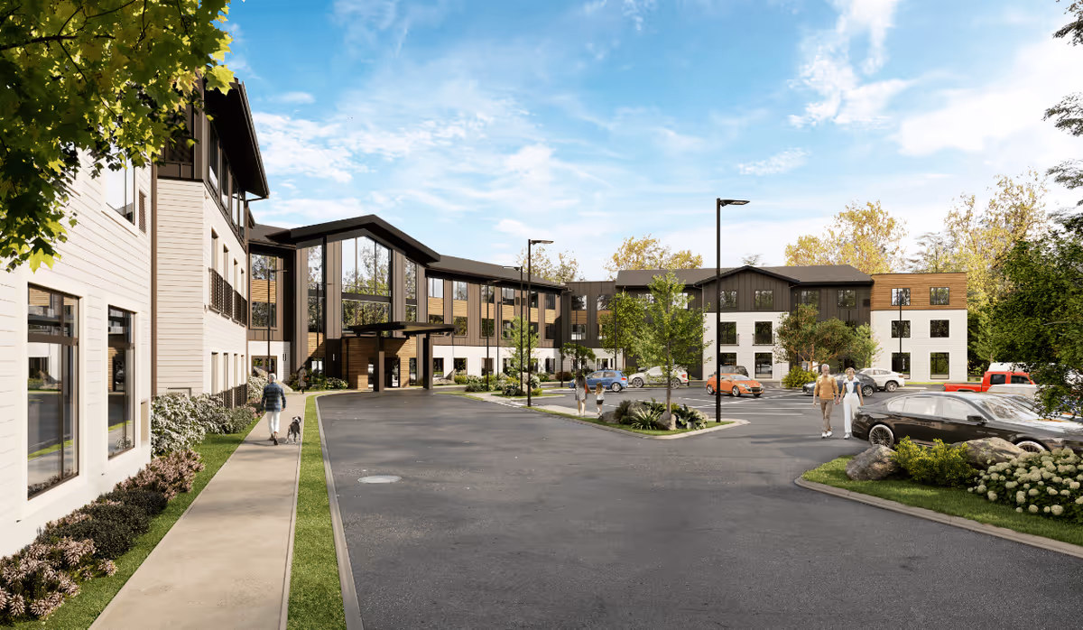 Front exterior of a modern three-story senior living building with a covered entrance, parking lot, landscaped grounds, and a few people walking nearby.