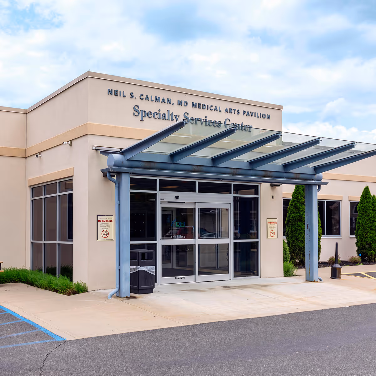 Front view of a medical facility entrance labeled Specialty Services Center with glass doors