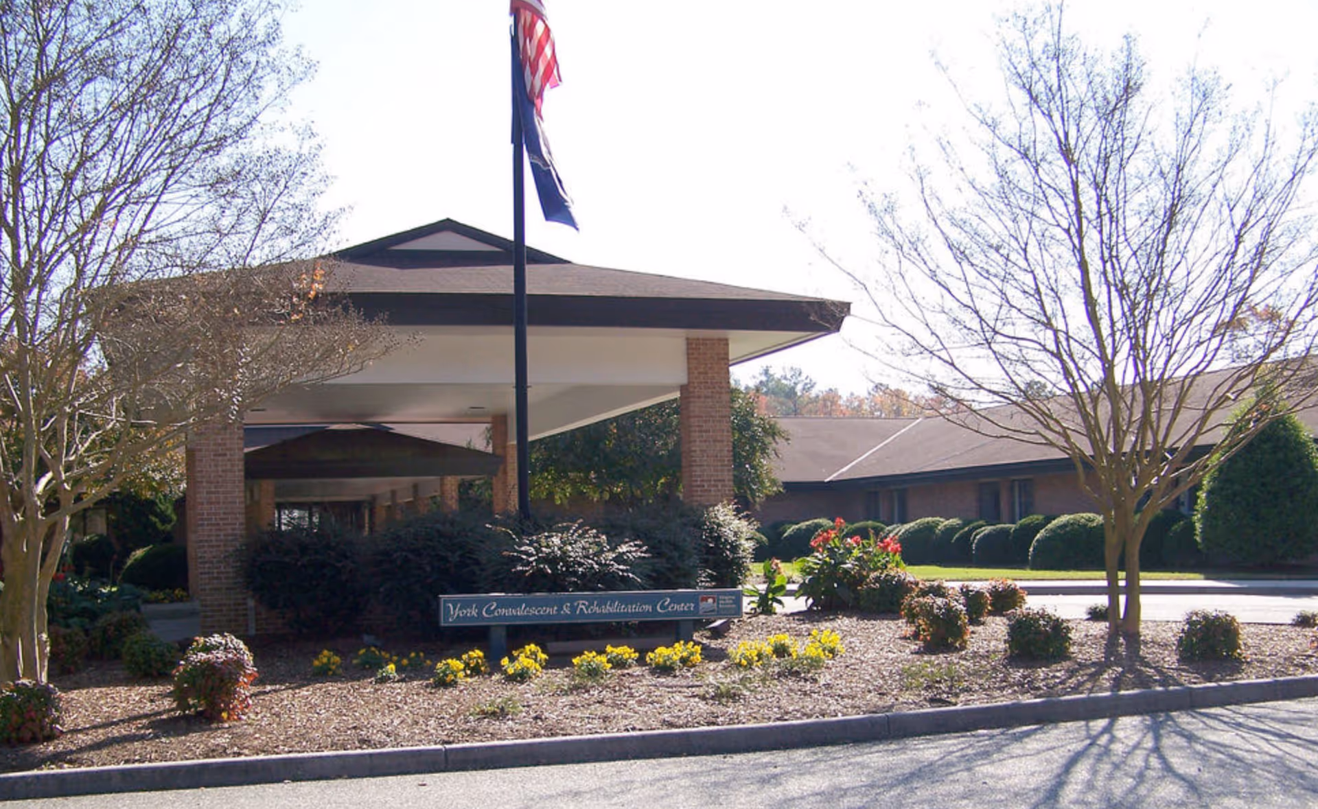 Front of York Convalescent & Rehabilitation Center with flagpole and landscaped entrance.