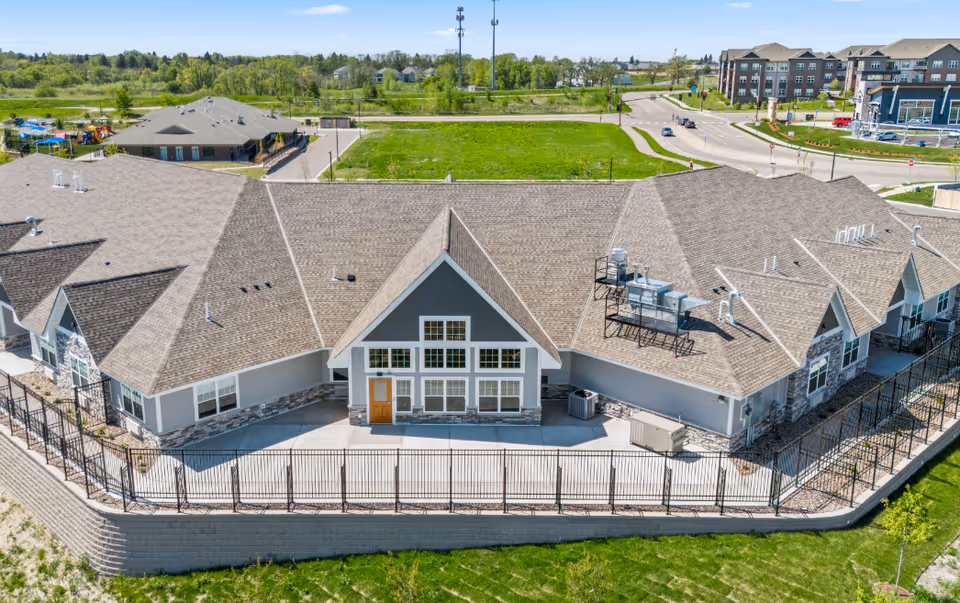 Aerial view of Suite Living Senior Care of Maple Grove exterior with multiple rooflines.
