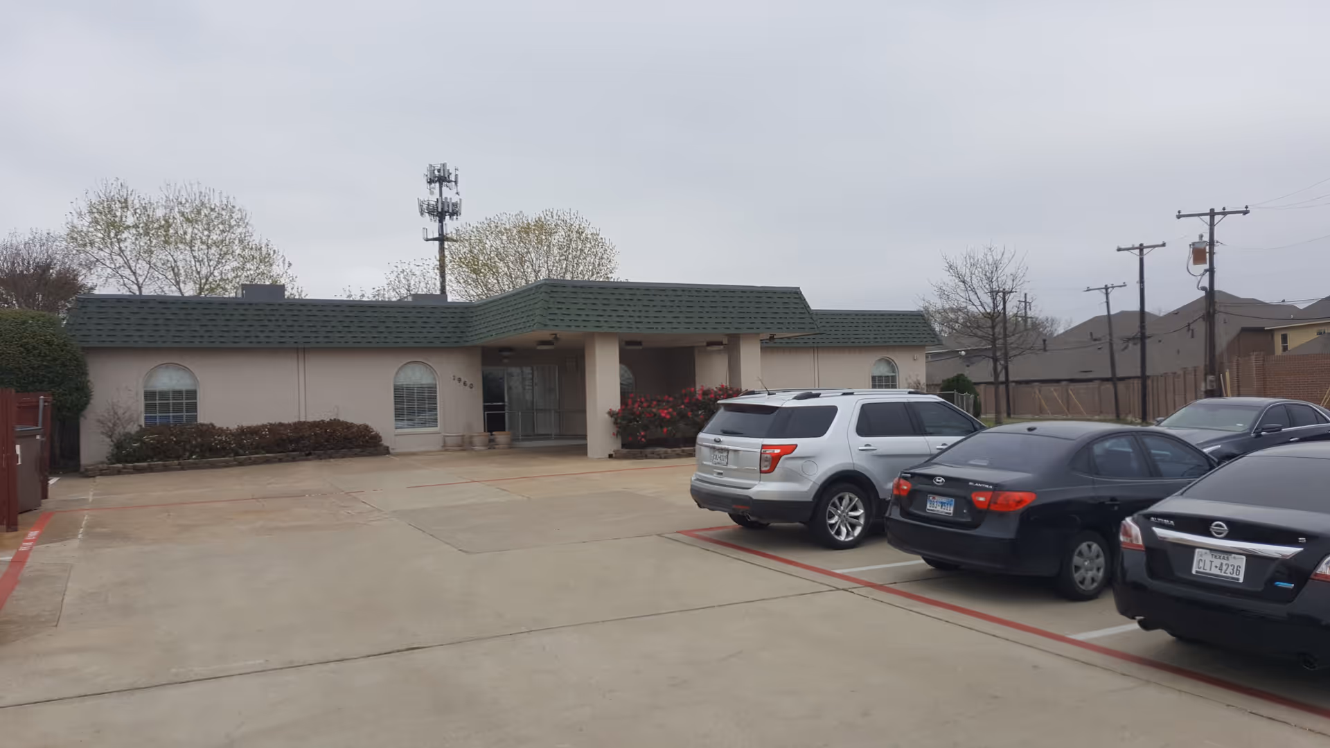 Front view of Friend's Place Adult Day Services building with green roof and parking.