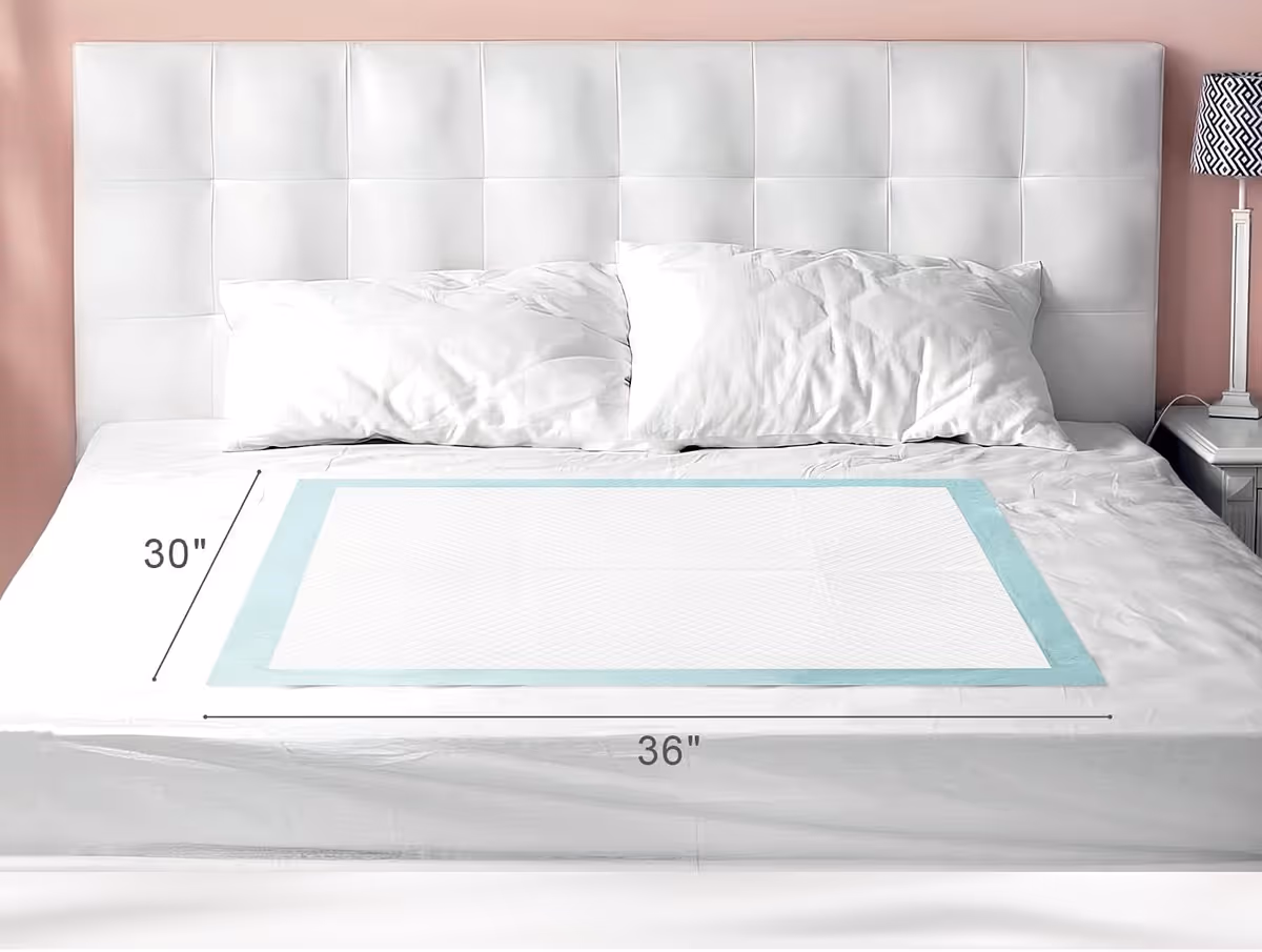 White bed with padded headboard in a pink bedroom; shows a 36x30 inch mattress.