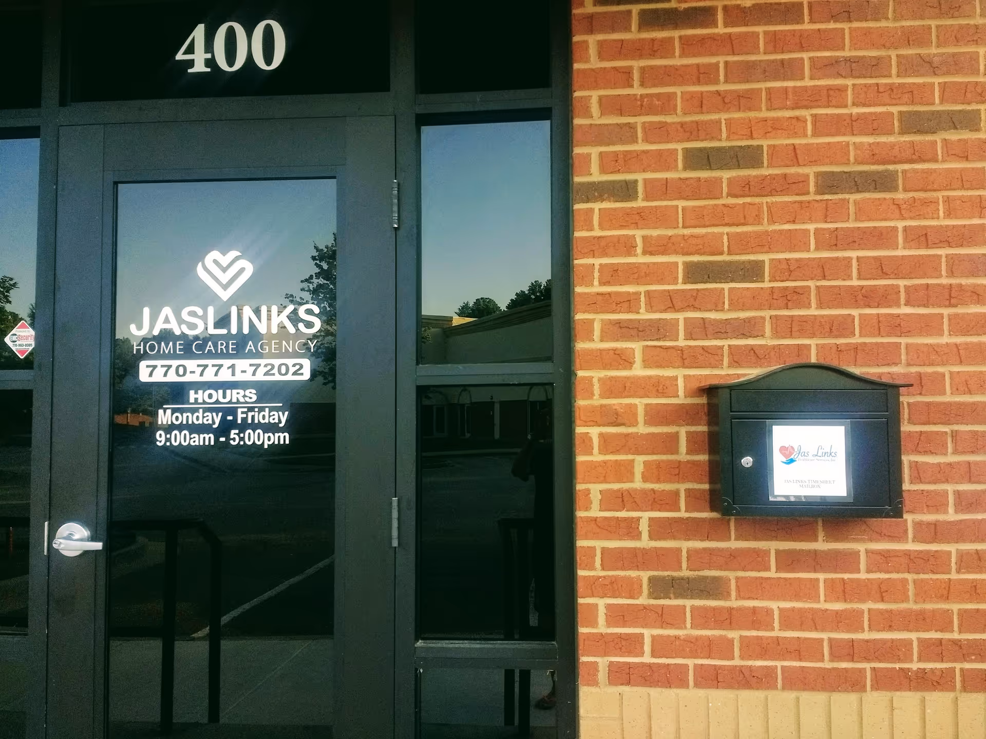 Brick building exterior with a glass door for JasLinks Home Care Agency, street number 400.