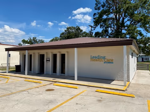 Small single-story building with a covered front porch and Leading Home Care sign.