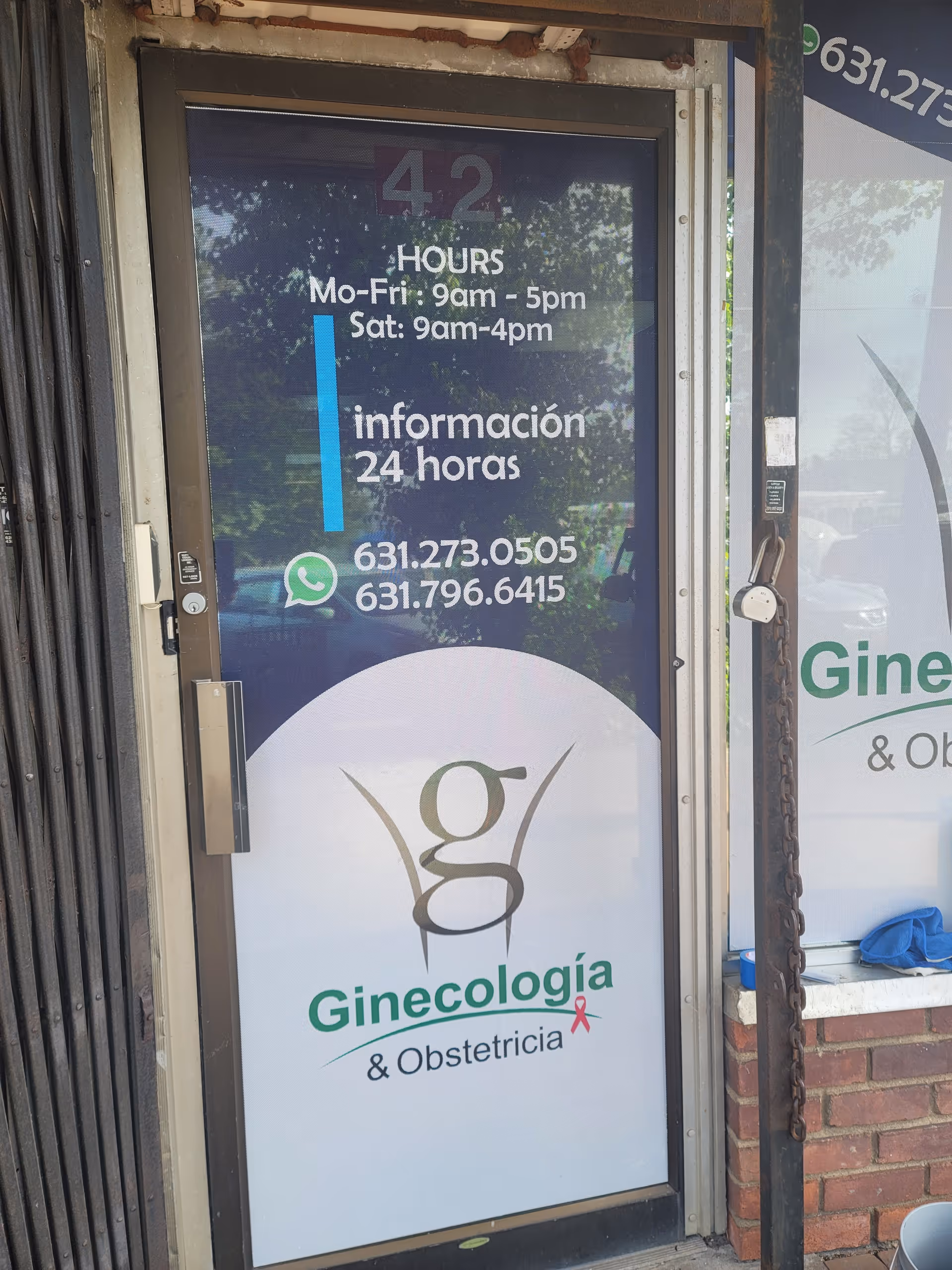 Front entrance of a gynecology clinic displaying hours and contact numbers.