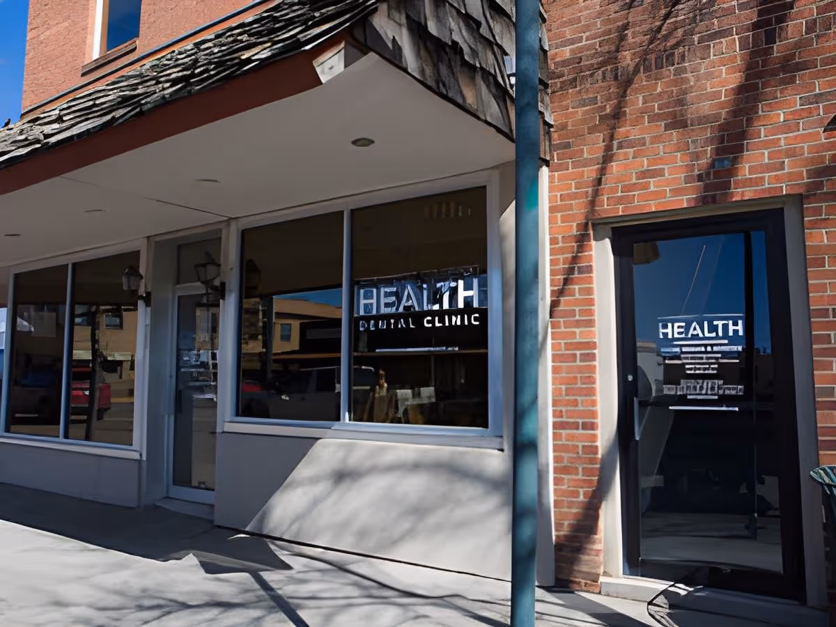 Exterior view of a brick health clinic storefront with glass doors and windows