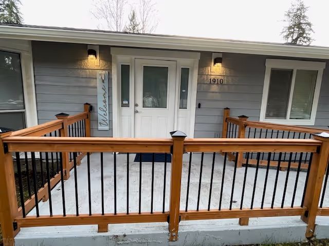 Front entrance of AVID Adult Family Home with a wooden railing deck.