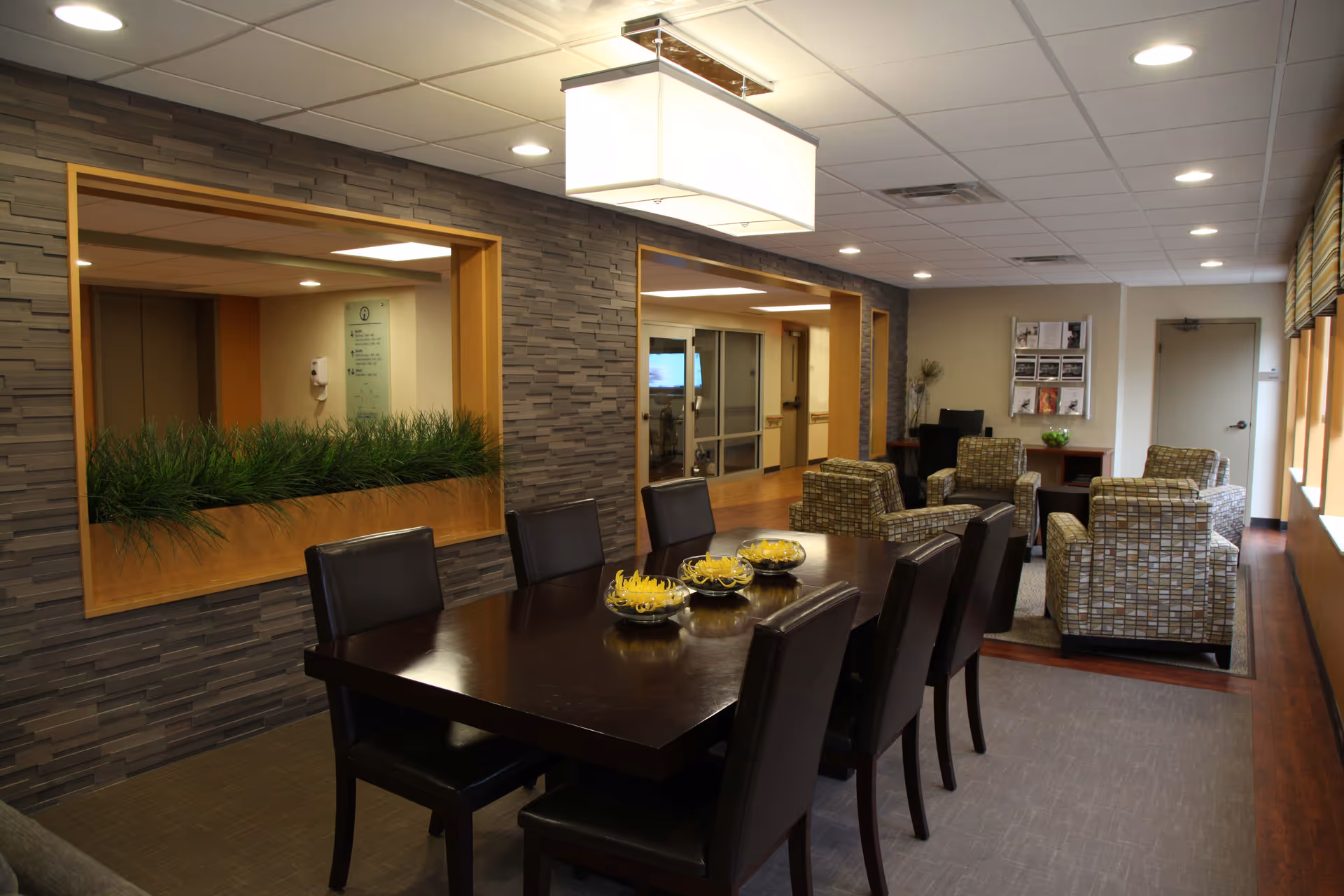 Interior common dining area at Burlington House Nursing Home with a long table and lounge seating.