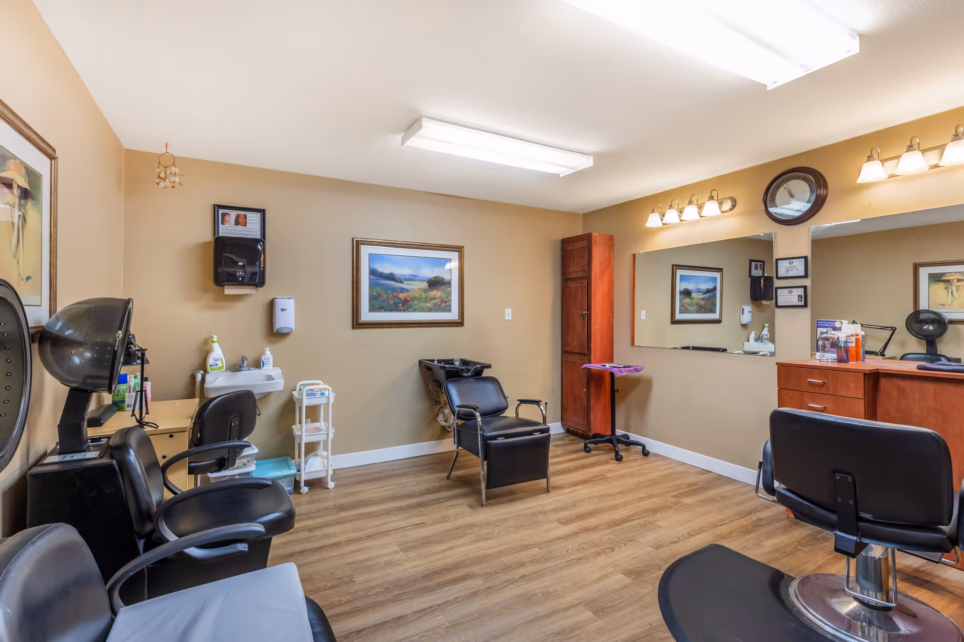 Interior senior living facility salon with styling chairs, mirrors, and wooden cabinetry.