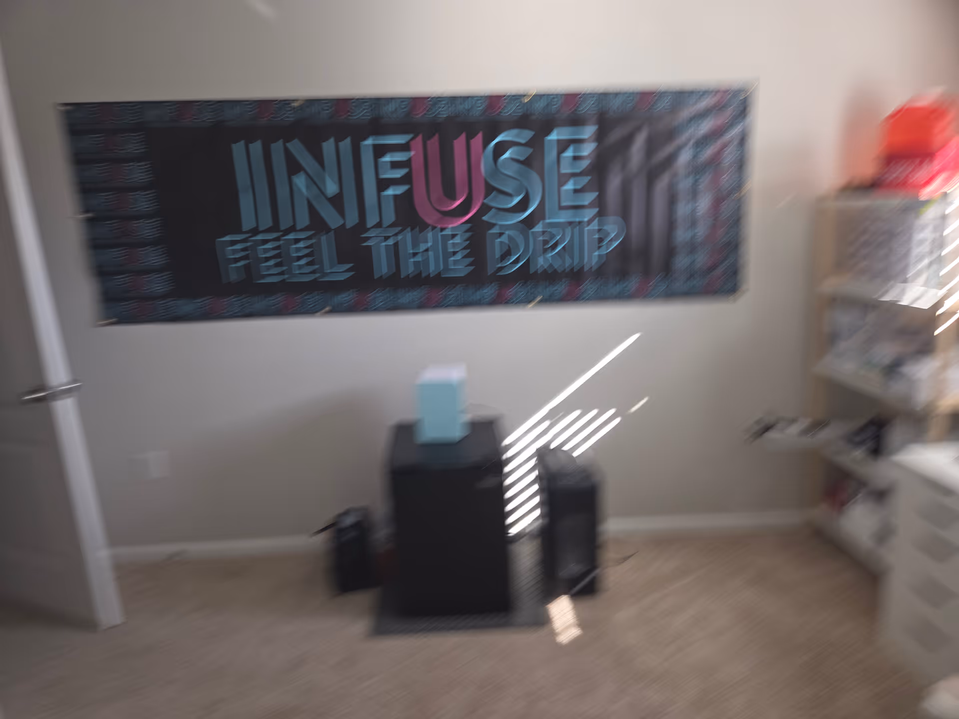 Blurry interior room with a large Infuse banner on the wall and furniture nearby.