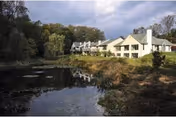Exterior view of Beaumont at Bryn Mawr campus beside a pond.