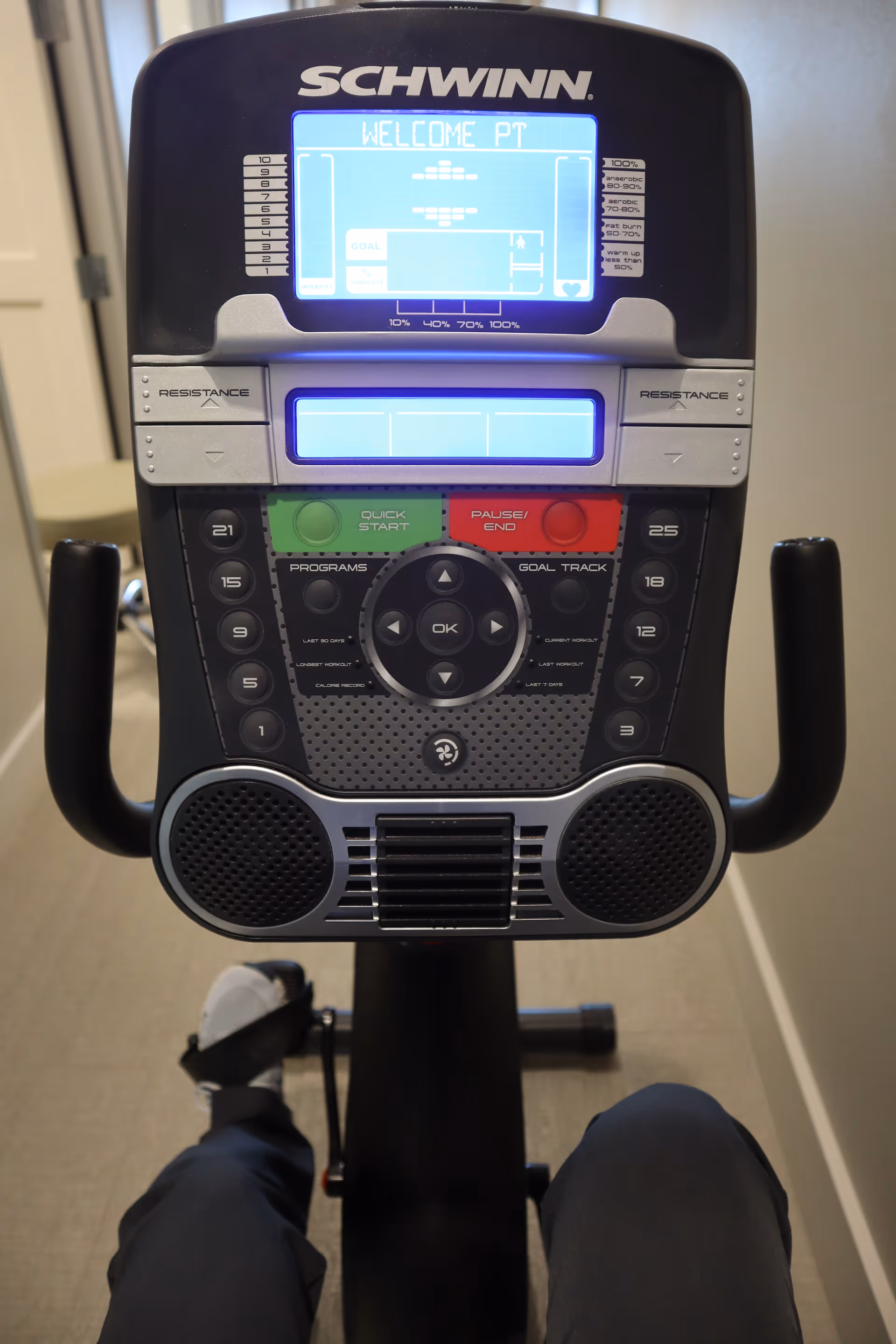 Schwinn exercise machine console in a therapy room with a leg visible on the pedal