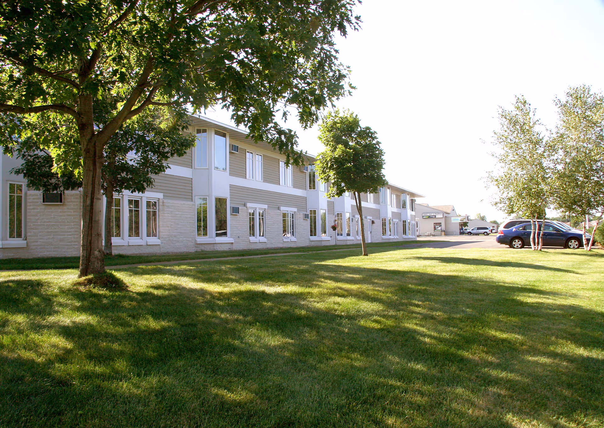 Exterior view of Country Manor Extended Service I with lawn and parked cars
