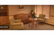 Cozy living room with sofa, chairs, and a vase on a small table.
