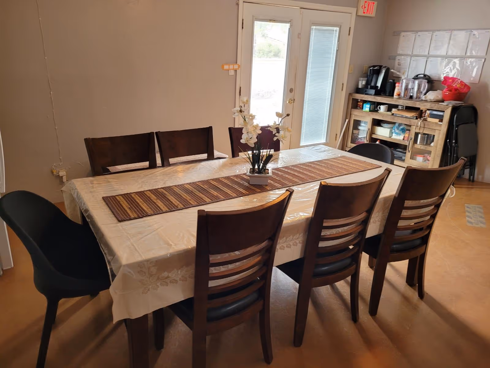 Long dining table with chairs in a communal dining room at Elim Palmtrees Assisted Living Home.
