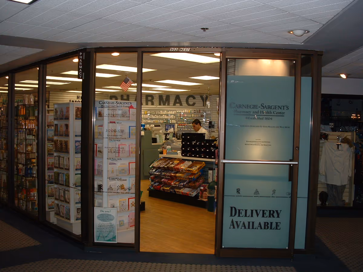Pharmacy storefront inside a building with delivery available sign