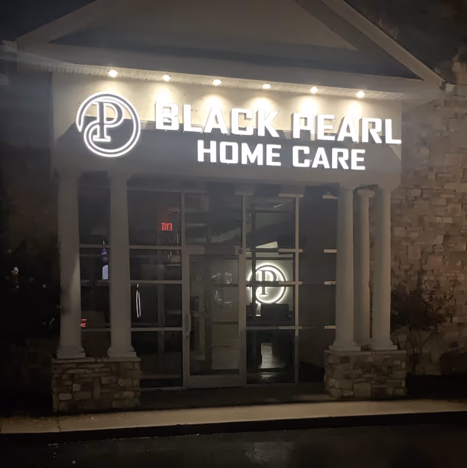Night exterior of Black Pearl Home Care front entrance with illuminated logo sign.