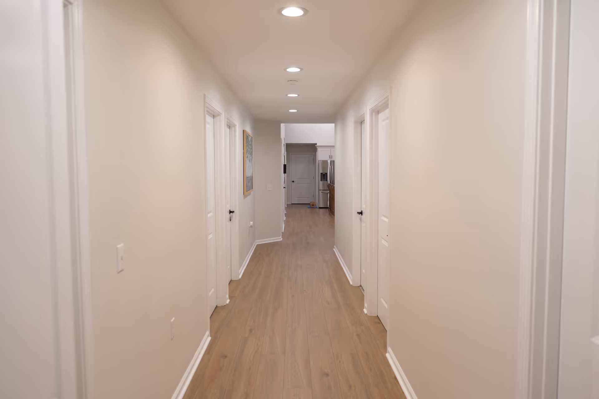 Bright hallway in a senior living facility with doors along both walls.