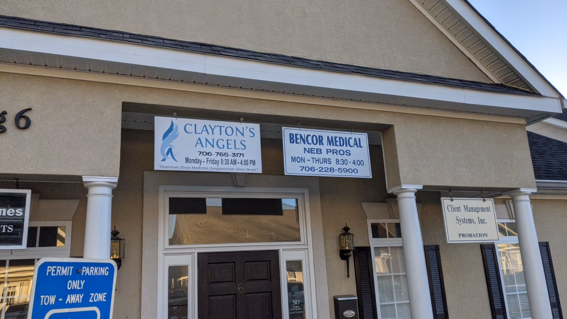 Front exterior of a beige building with Clayton's Angels sign and storefronts.